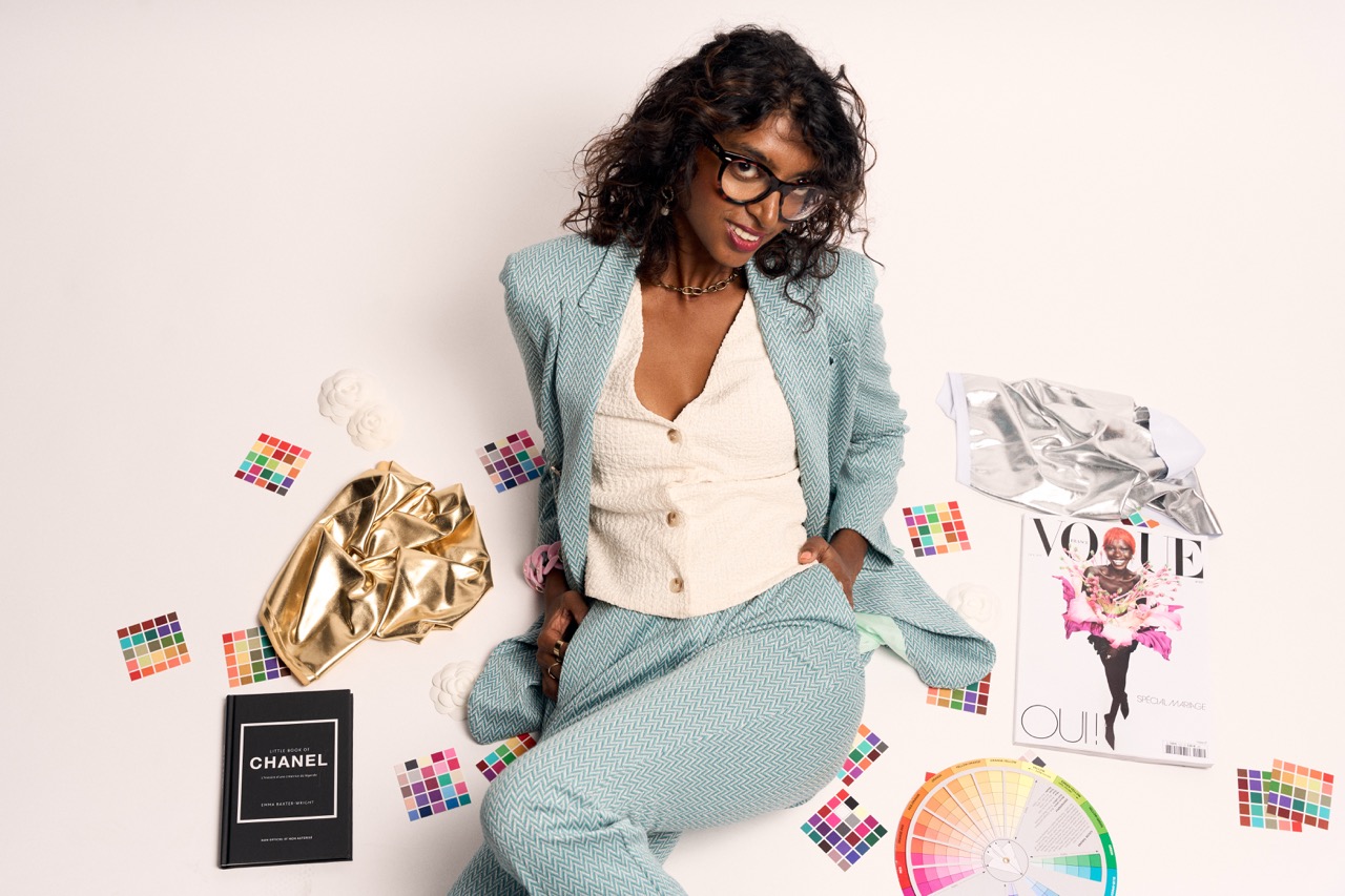Madhuri, conseillère en image à Lille, posant au milieu de palettes de colorimétrie, nuanciers et magazines de mode